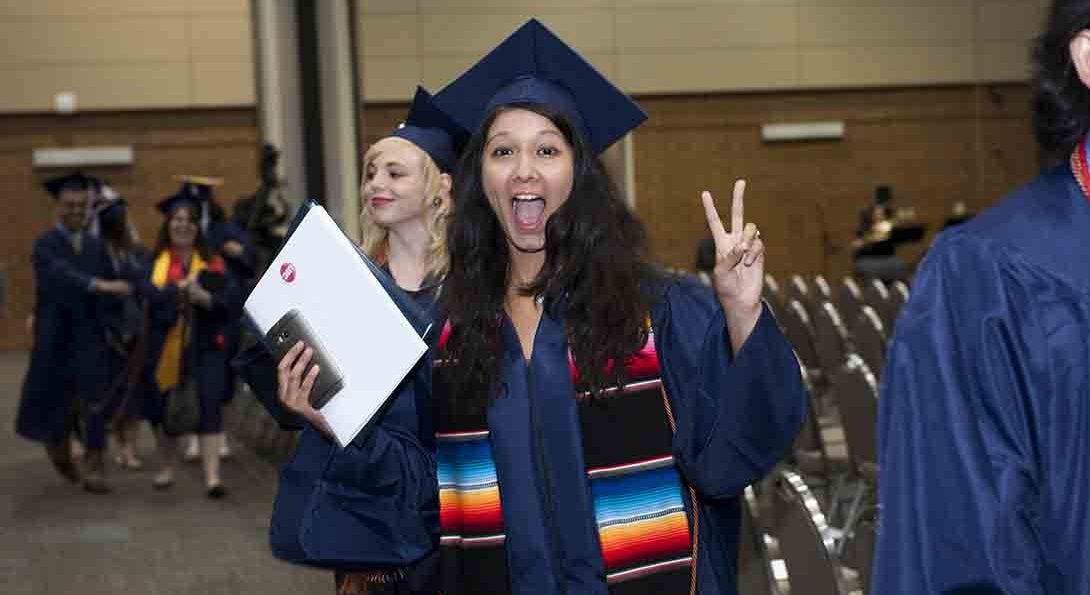 Graduate showing peace sign.