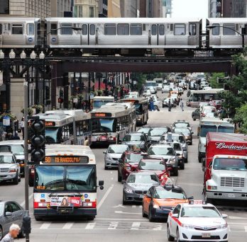 Chicago Street scape with buses, cars, and trains.
                  