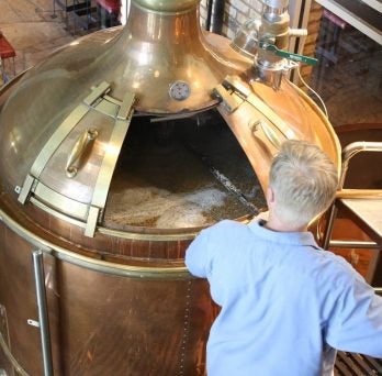 Man working near a beer barrel container.
                  