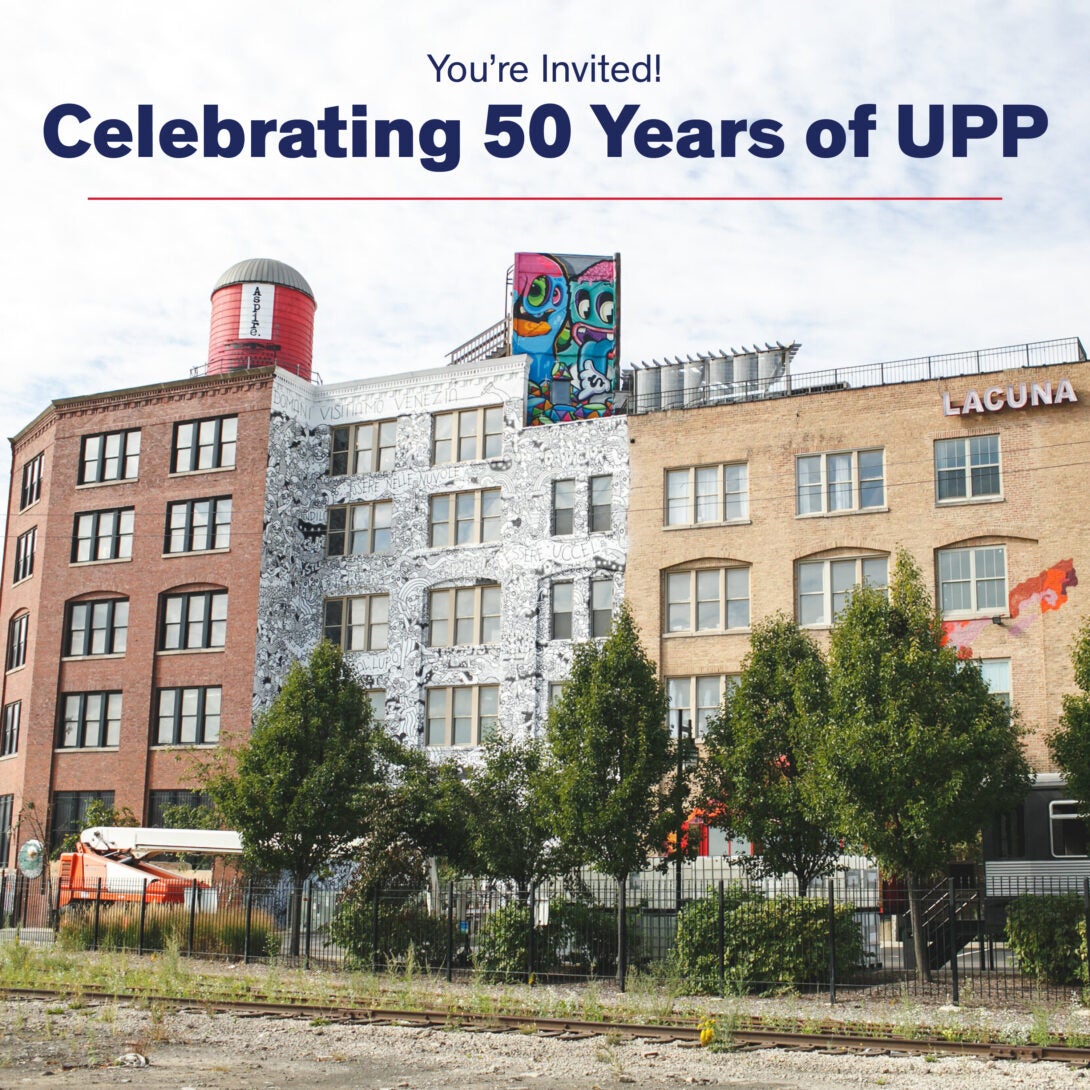 an old warehouse painted with murals and trees in the front of the building