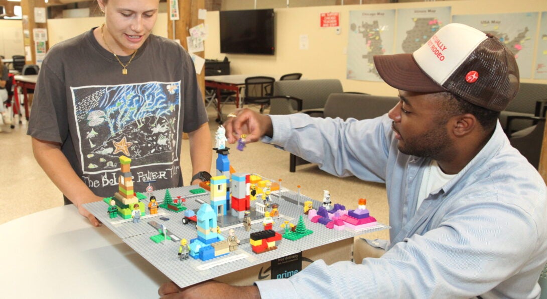 Two CUPPA students assemble a city made out of Lego bricks