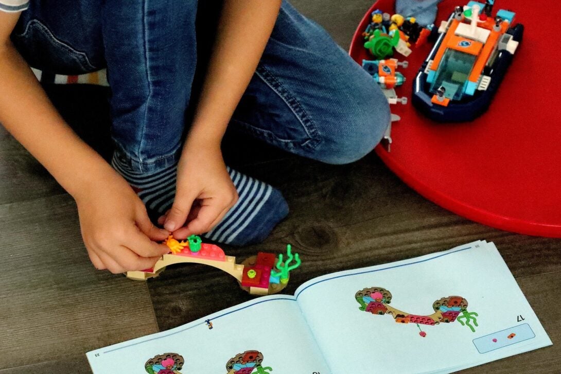 A child reading the directions for a lego design assembly.