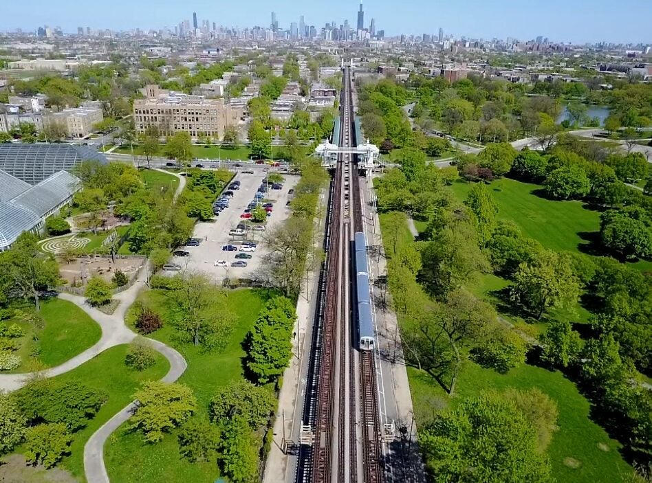 Birds eye view of train line south of Chicago with train heading directly toward the city to the north.