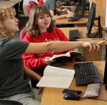 Two students work together on a computer 