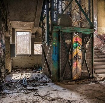 interior shot of an old factory run down and graffitied. 