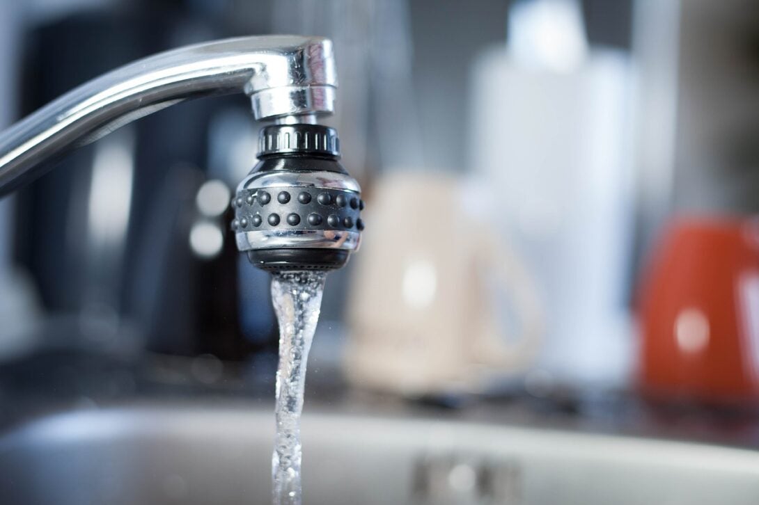 Silver sink faucet with running water