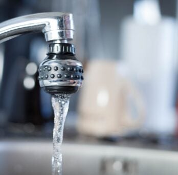 Silver sink faucet with running water 